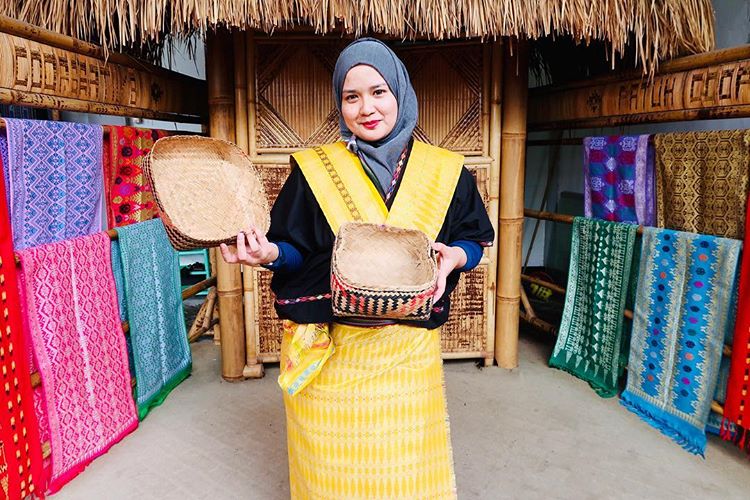 Berfoto dengan kain tenun pakaian adat lombok di desa sukarara